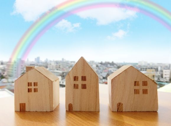 木製の家の模型と虹